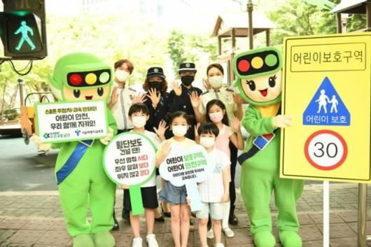사진=도로교통공단/어린이들이 경찰관, 서울녹색어머니연합, 도로교통공단 교통안전교육지도사와 함께 어린이보호구역 교통안전을 위한 사진을 촬영하고 있다.<br>