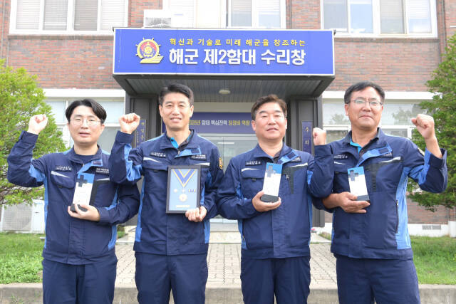 해군 2함대 수리창 앞에서 (왼쪽부터)지동환 주무관, 이종용 주무관, 김형삼 사무관, 김양엽 주무관이 헌혈 명예장을 들고 기념사진을 촬영하고 있다. 2함대 제공