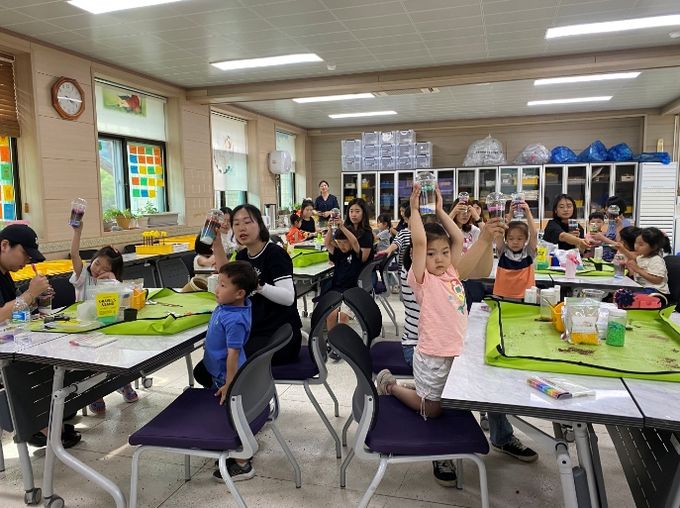 원아와 학부모들이 플라스틱 컵을 활용해 다육이 화분을 만들고 있다.