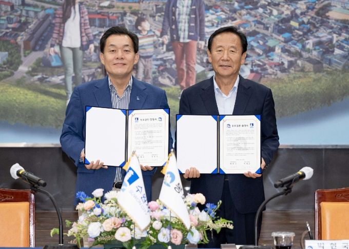 이재준 수원시장(왼쪽)과 박현국 봉화군수(오른쪽)가 우호도시 협정서를 들어 보이고 있다.