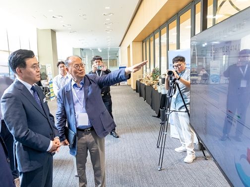 진교훈 강서구청장(왼쪽 첫 번째)이 ‘강서구 중소기업 수출상담회’를 찾아 관계자로부터 기업과 해외 바이어 간 수출계약 상담 현황에 대해 설명을 듣고 있다.