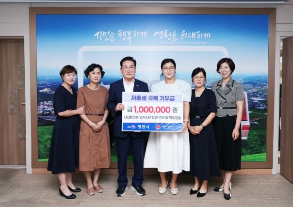 (사)한국여성농업인 영천시연합회 임원 및 회원과 최기문 영천시장이 기탁식에서 기념촬영을 하고 있다.