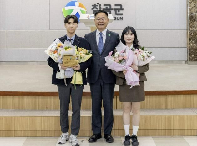 교복 입은 유공자들”–김재욱 칠곡군수가 군정 유공 표창을 받은 김동준(왼쪽), 이선영(오른쪽) 학생과 기념촬영을 하고 있다. 두 학생은 지난 1일 칠곡군청 정례조회에서 18명의 성인 유공자들과 함께 이례적으로 단상에 올라 표창패를 받았다.