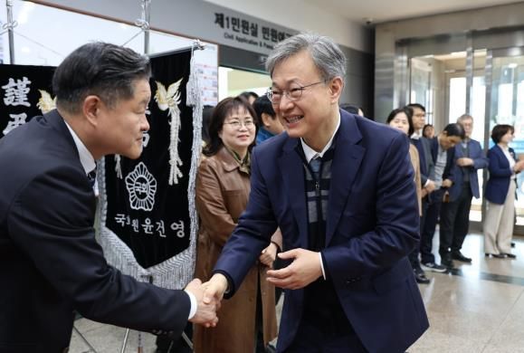 장인홍 구로구청장이 3일 구청 현관에서 직원과 악수하고 있다.