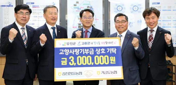 강진한들농협과 고흥거금도농협 임직원들이 고향사랑기부금 상호기부를 하고 있다.