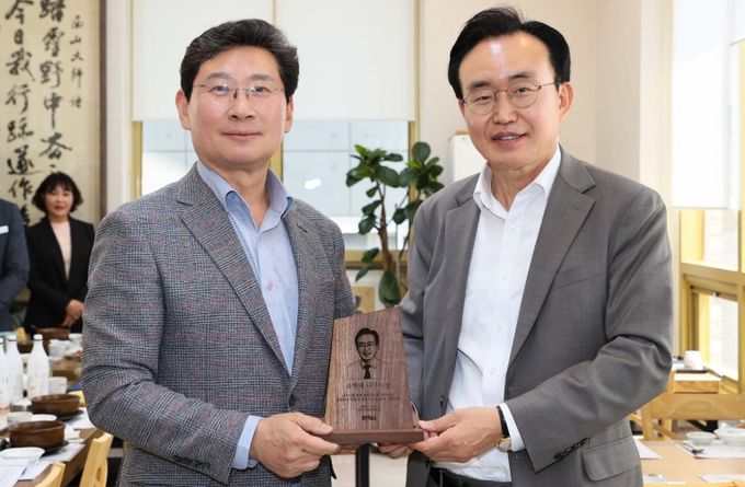 25일 이상일 용인특례시장(왼쪽)이 윤병태 나주시장에게 목재 기념패를 전달하고 있다.