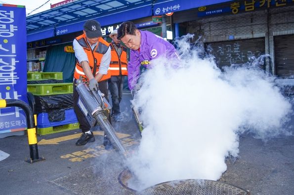 이필형 동대문구청장(사진 가운데)이 전통시장 맨홀 방역소독에 참여하고 있다