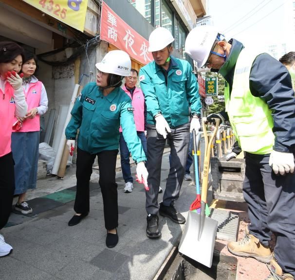 올해 4월 24일 박희영 용산구청장(왼쪽에서 3번째)가 이촌1동 빗물받이 준설 현장에서 주민에게 빗물받이 퇴적물을 보이며 설명 중이다