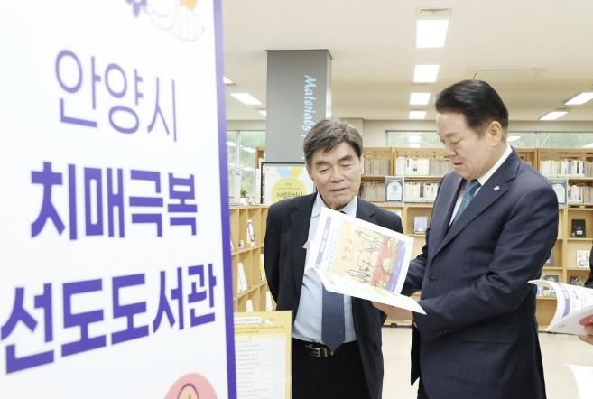 2025년 4월9일 석수도서관에서 열린 치매극복 선도도서관 지정 현판식에 참석한 최대호 안양시장이 도서를 살펴보고 있다