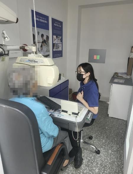 어르신이 안경원에서 시력 검사를 하고 있다