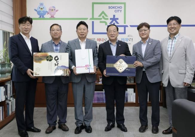 서태원 가평군수(사진 왼쪽 세번째)와 이병선 속초시장(사진 왼쪽 네 번째) 등이 각 지자체 특산품중 하나인 오징어와 막걸리를 교환하고 있다.