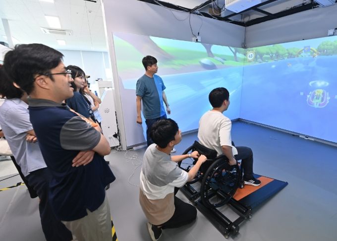 9일 ㈜에어패스에서 XR 스포츠 콘텐츠 ‘휠체어 레이싱’을 체험 중인 참가자가 휠체어 트레드밀 위에서 아바타와 함께 실시간 경주를 즐기고 있다.
