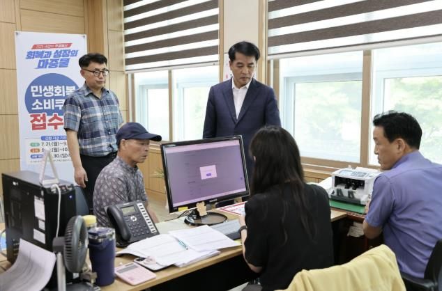 주민들이 소비쿠폰을 신청하는 모습