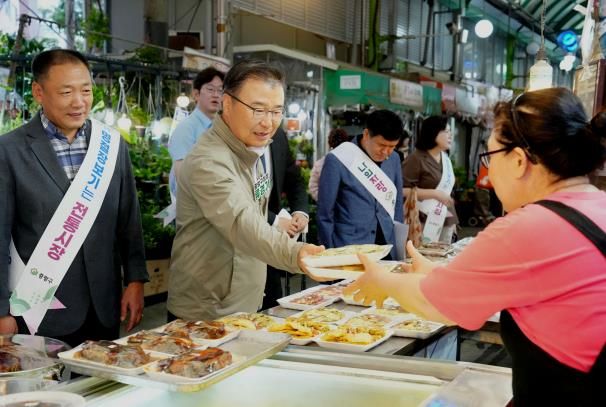 면목시장에서 상인과 이야기를 나누며 장보기 중인 류경기 중랑구청장의 모습