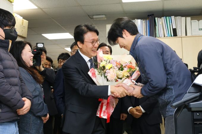 김민석 국무총리가 20일 경주시청 APEC 현업 부서를 방문해 직원에게 꽃다발을 받고 격려 인사를 건네고 있다.