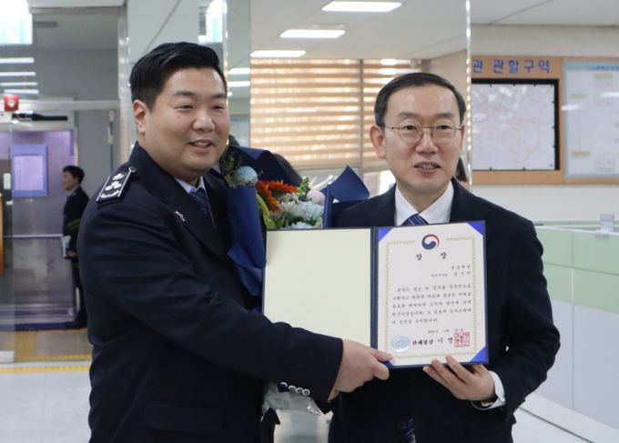 이명구 관세청장(오른쪽)이 29일 성남세관을 방문하여 정시진 주무관에게 상장과 포상금을 수여한 뒤 기념 촬영하고 있다.